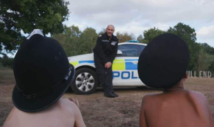 Two children listening attentively to a policeman.